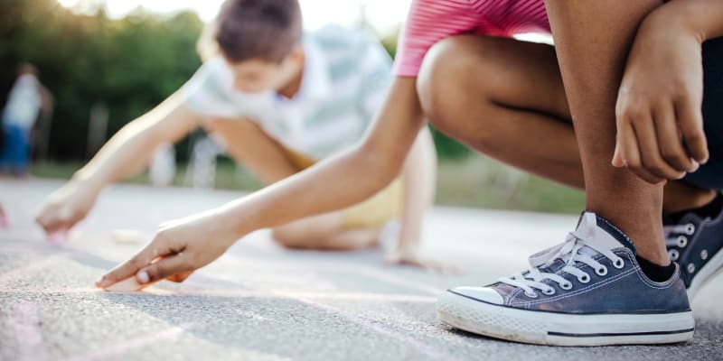 Children writing with sidewalk chalk at a school near Columbia Colony in Patuxent River, Maryland