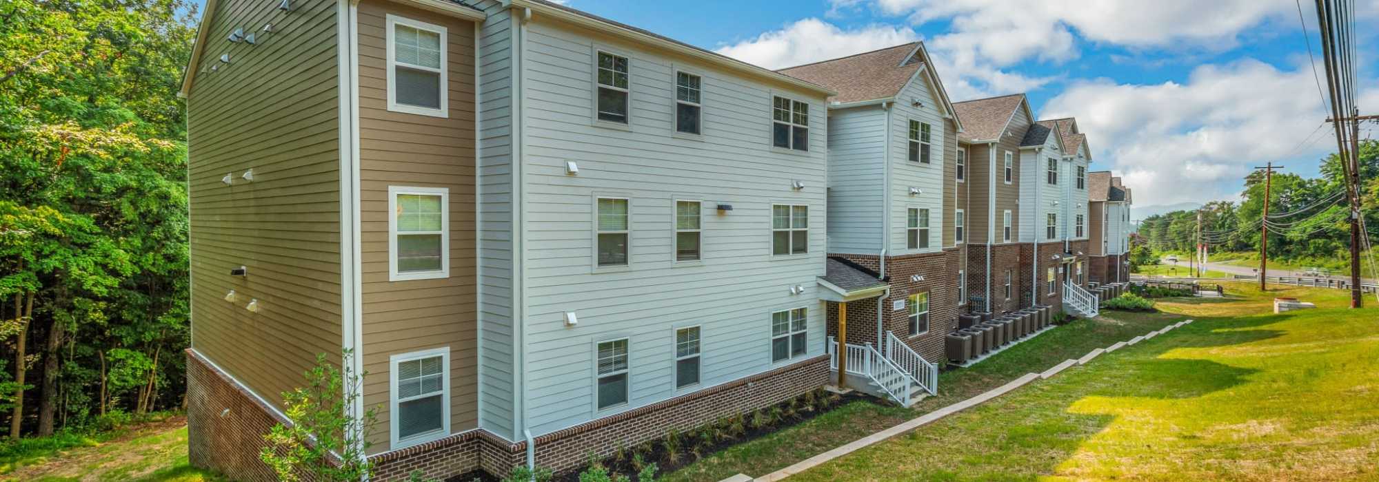 Exterior view of apartments surrounded by greenery at Magnolia Greene in Lavale, Maryland