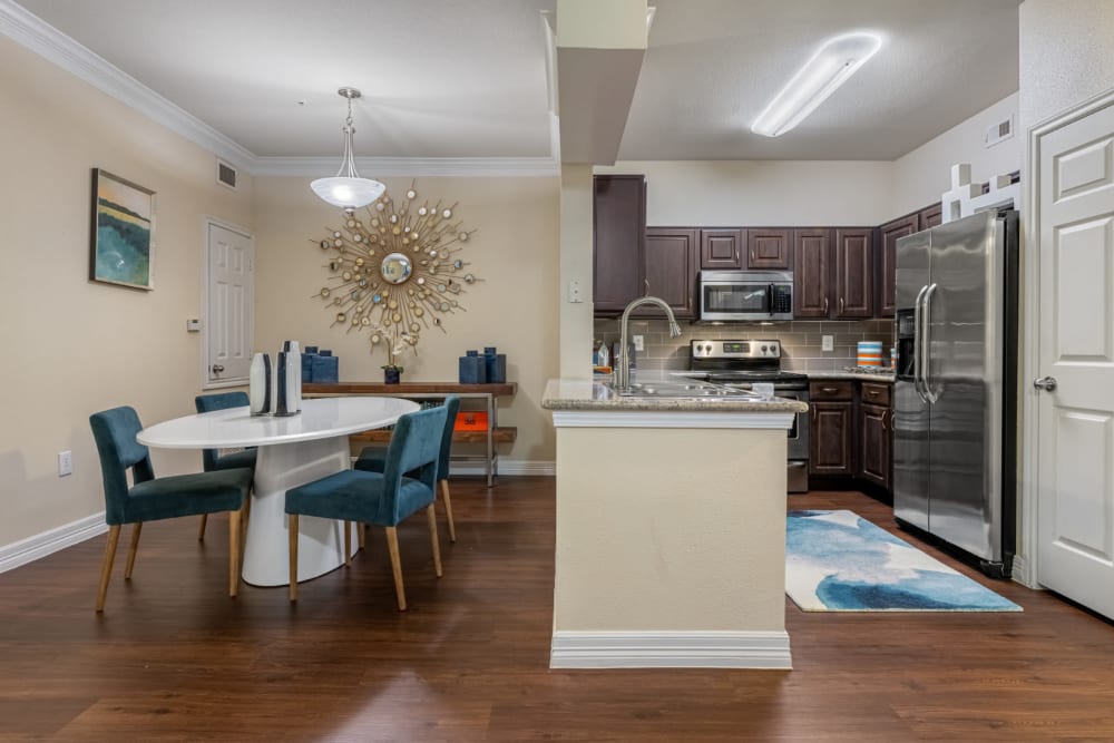 Colorful dining area across from kitchen with granite counters at Marquis at Kingwood in Kingwood, Texas