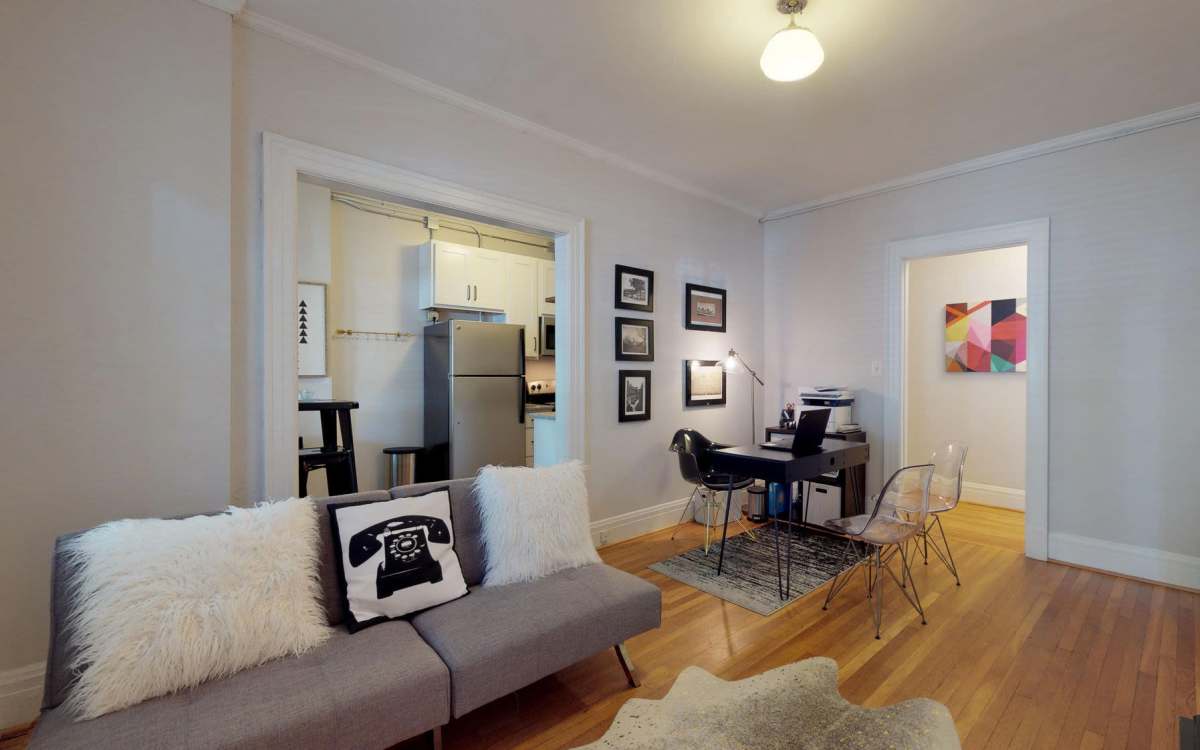 Living room with a couch connecting to a kitchen at Historic Boylan Apartments in Raleigh, North Carolina
