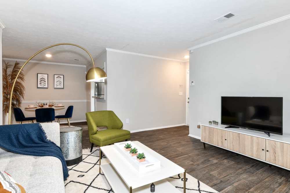 Spacious living room with couch, chairs, coffee table, flat screen television and wood-style flooring at Preserve at Dunwoody in Dunwoody, Georgia