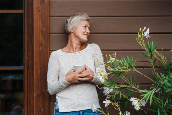 A resident enjoying a cup of coffee outside her home