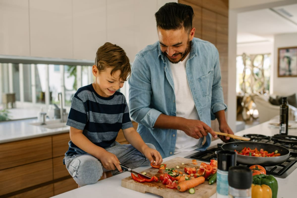 A father and son prepare a meal in their kitchen at Playa Pacifica, Playa Del Rey, California