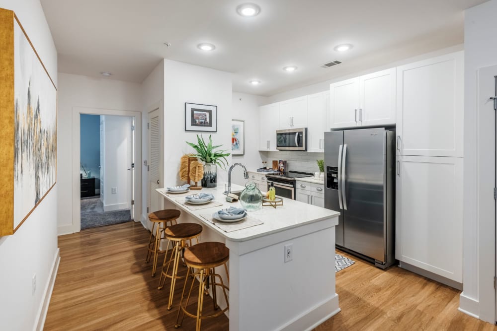 Bright kitchen with island and barstool seating at The Collins in Charlotte, North Carolina