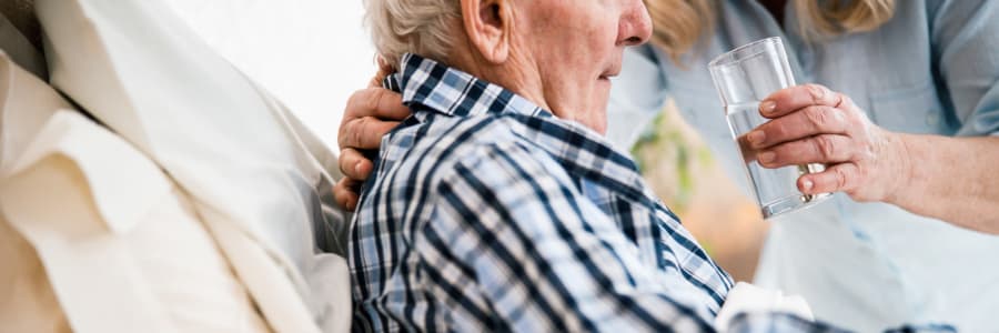 Resident in hospice care being given a drink of water by a caretaker at Edgerton Care Center in Edgerton, Wisconsin