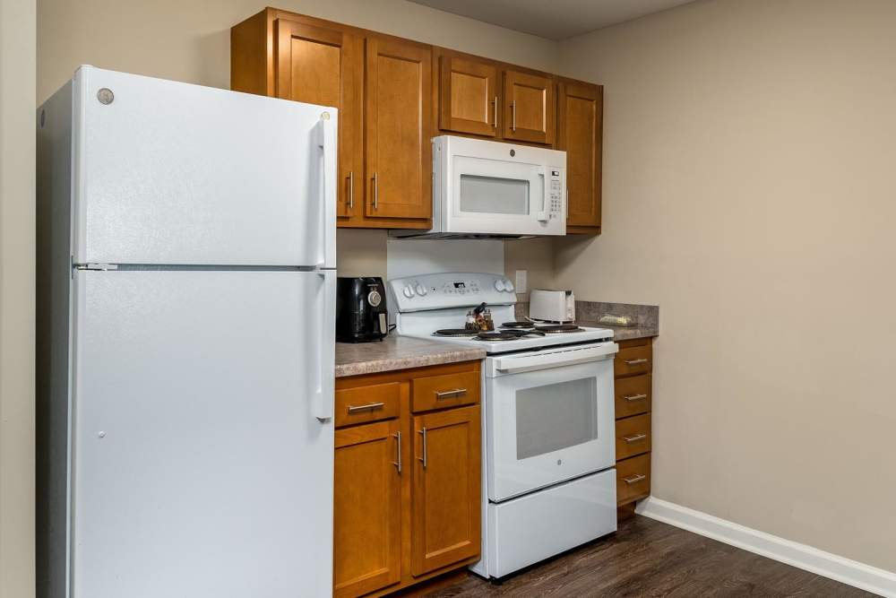 Modern kitchen with stainless steel appliances, granite countertops, and wood-style flooring at Labelle Greene IV in Wheeling, West Virginia