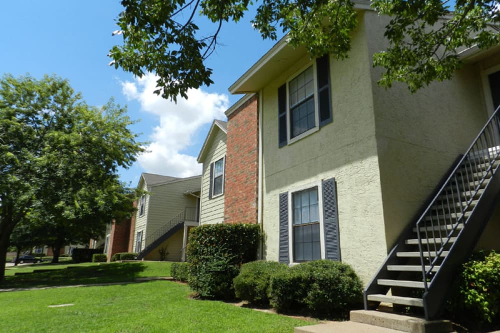 Lush green lawn and stairwell leading to apartments at Pecan Ridge in Midlothian, Texas