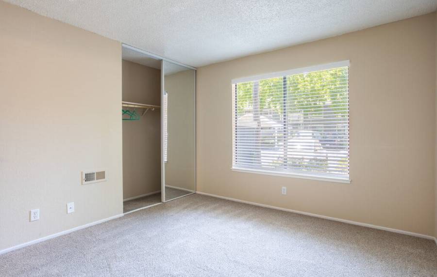 Unfurnished bedroom with window and carpet flooring at Amber Court in Fremont, California