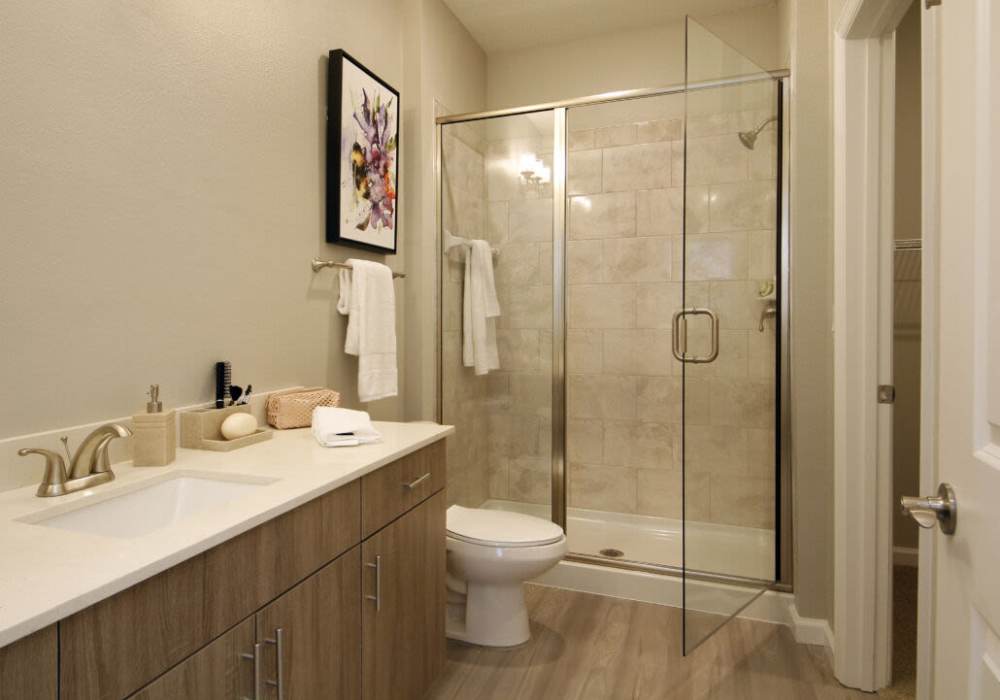 Modern bathroom with glass shower and elegant vanity at Messina Luxury Apartments in New Smyrna Beach, Florida