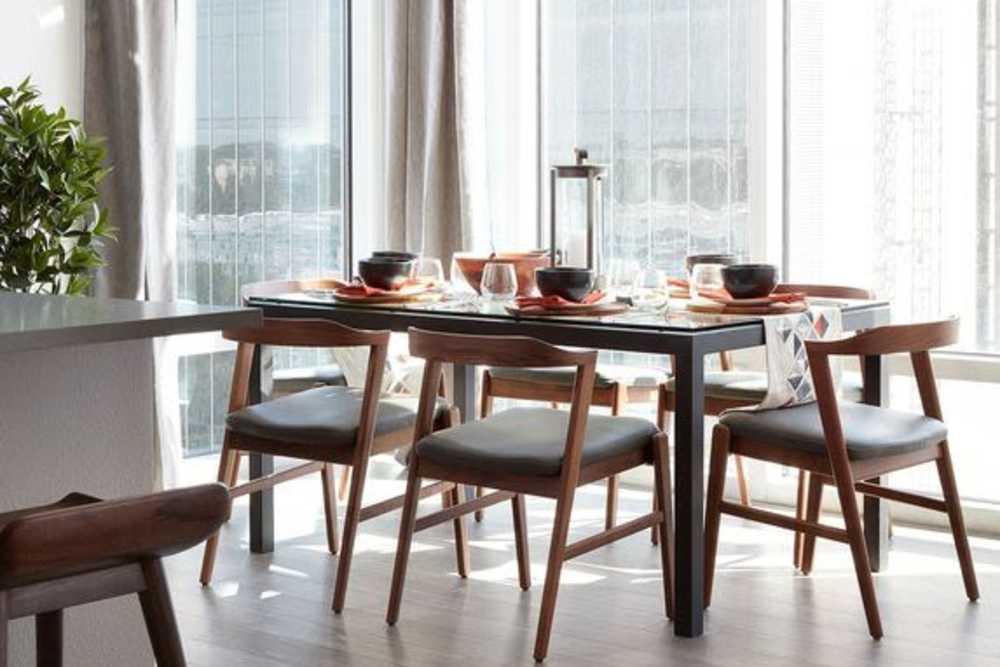 Dining table facing towards large window at Ardan in Dallas, Texas