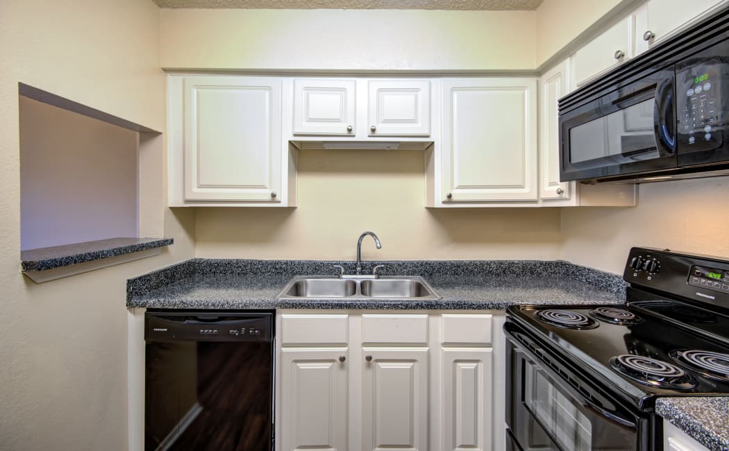 Gourmet kitchen white cabinetry and granite countertops in model home at Grayson Ridge in North Richland Hills, Texas