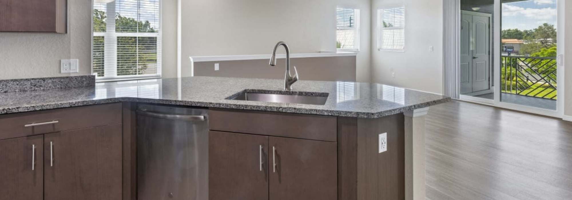 Granite countertops and gooseneck faucet in kitchen at The Bergamot Apartments On 780 in Sarasota, Florida