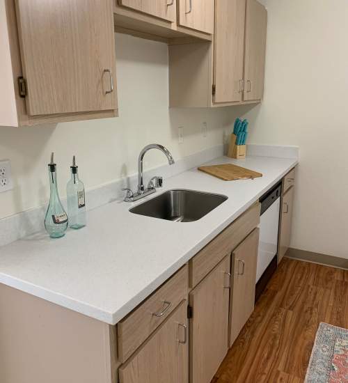 Kitchen with white counters and stainless steel sink at Foundry on Fifth in Renton, Washington