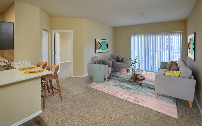 Living room with a private patio at The Crossings at Bear Creek Apartments in Lakewood, Colorado