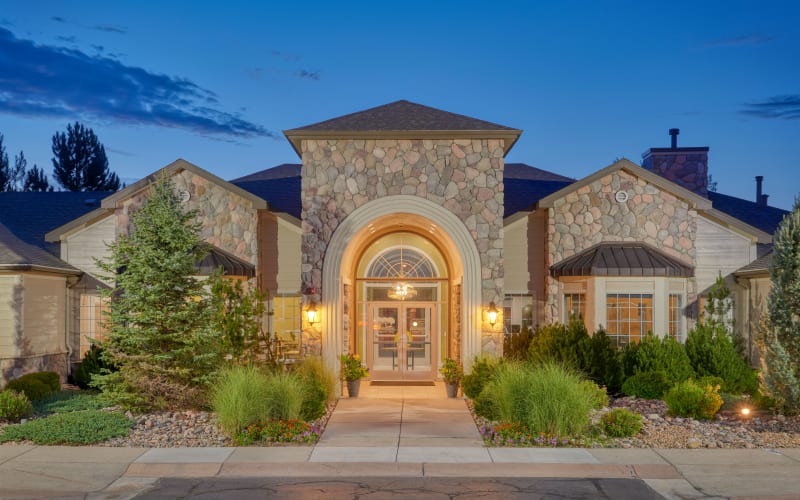 Exterior clubhouse view with beautiful landscaping at sunrise at Legend Oaks Apartments in Aurora, Colorado