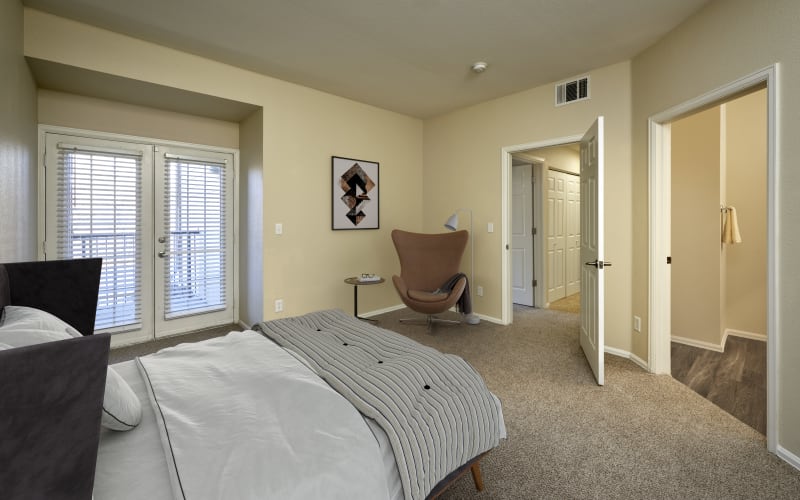 Spacious master bedroom with plush carpeting at The Crossings at Bear Creek Apartments in Lakewood, Colorado