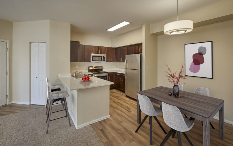 Renovated kitchen with brown cabinets at The Crossings at Bear Creek Apartments in Lakewood, Colorado