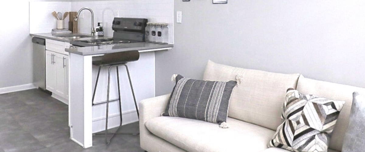 Cozy sitting area with white couch and counter top dining at The Gateway Apartments in Mobile, Alabama