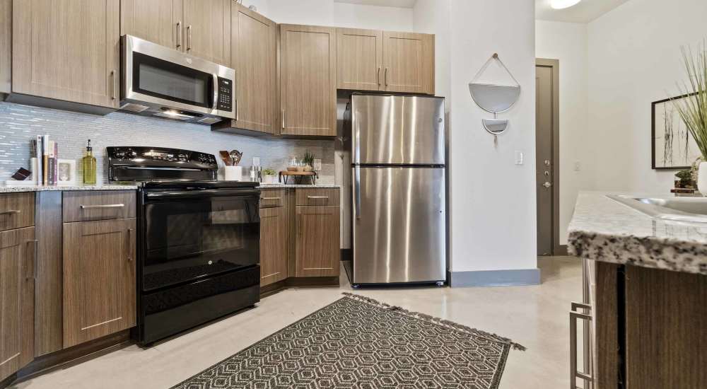 Kitchen with granite countertop and range at Millennium Place in Corinth, Texas