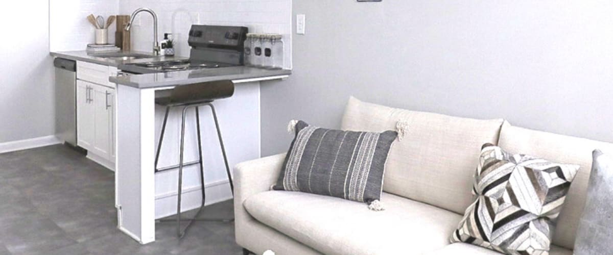 White sofa with counter dining seating at back at The Gateway Apartments in Mobile, Alabama