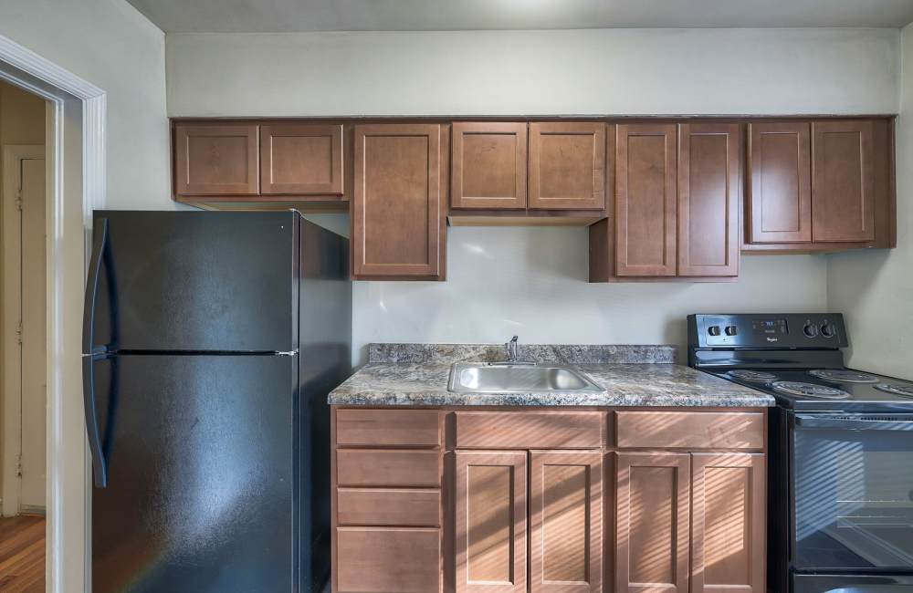 Kitchen featuring granite countertops, stainless steel appliances, and wooden cabinets at Fordleigh Apartments in Baltimore, Maryland