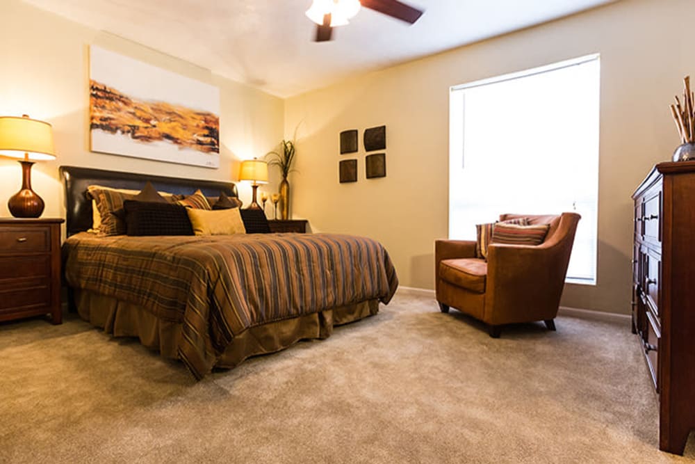 Spacious model bedroom with ceiling fan at Riverstone Apartments in Bryan, Texas