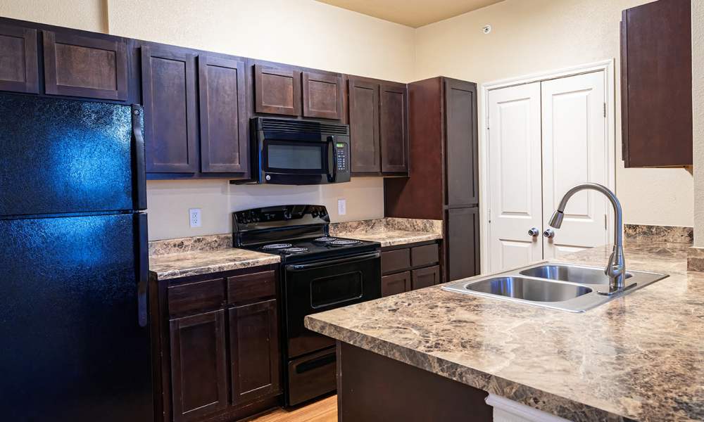 Kitchen with wooden cabinets at Sunset Lodge in Odessa,Texas