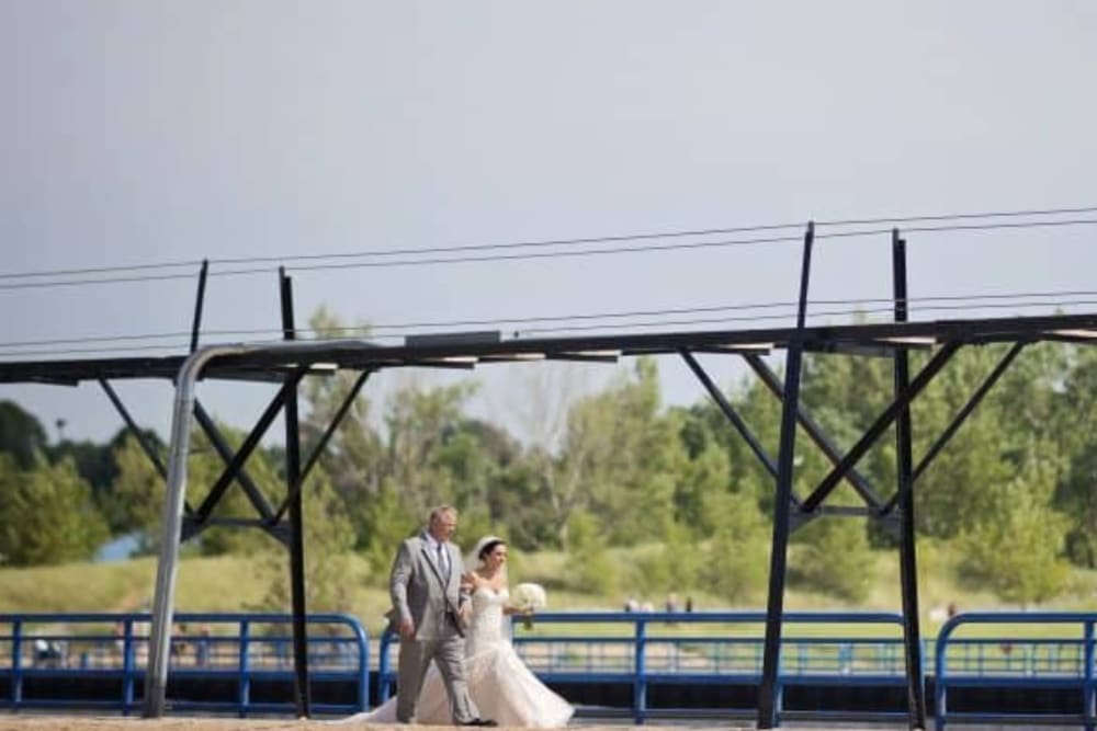 Bride and groom walking outdoors together at The Whitcomb Senior Living Tower in St. Joseph, Michigan