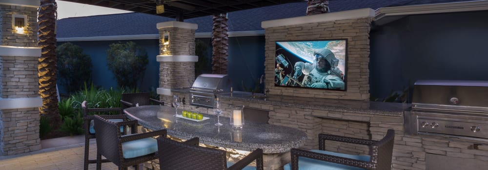 An outdoor lounge with bar seating and a flat-screen TV at Greenhouse in Houston, Texas