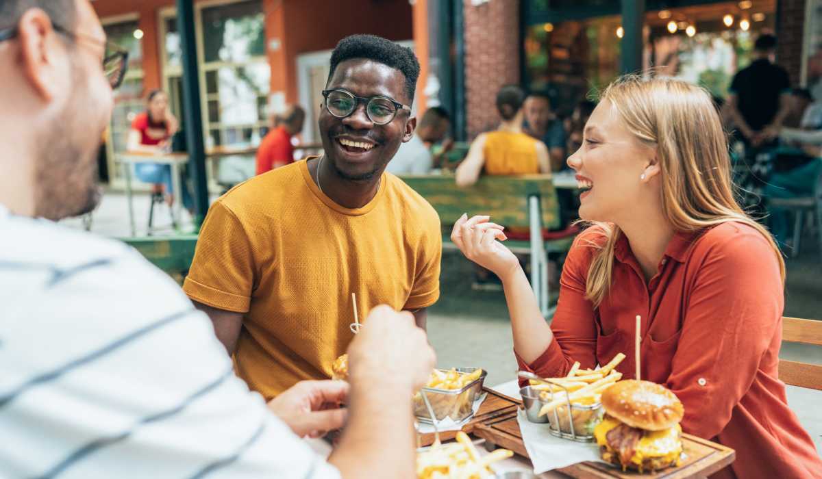 Friends dining outdoors near Art Avenue Apartment Homes in Orlando, Florida