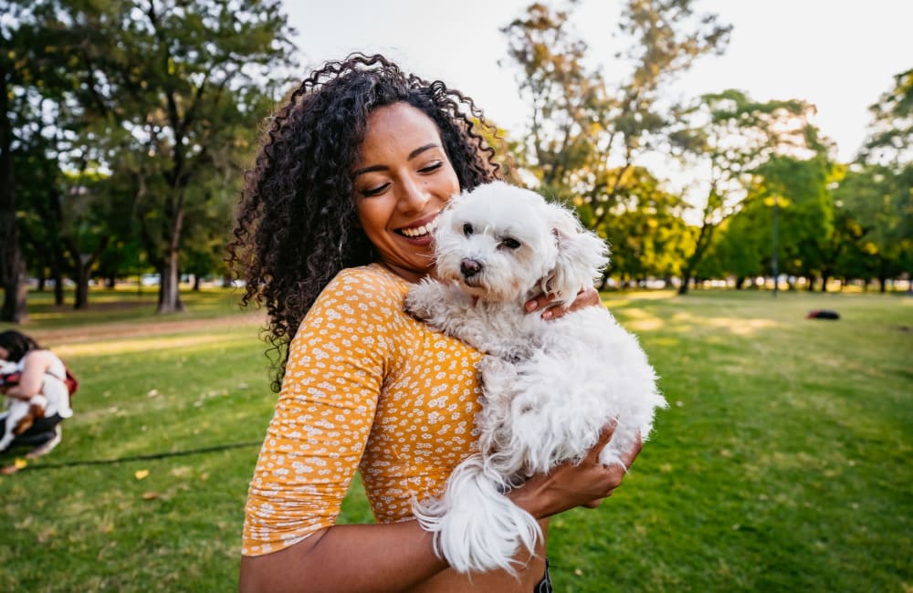 Resident holding her dog at a dog park near The Haylie in Garland, Texas