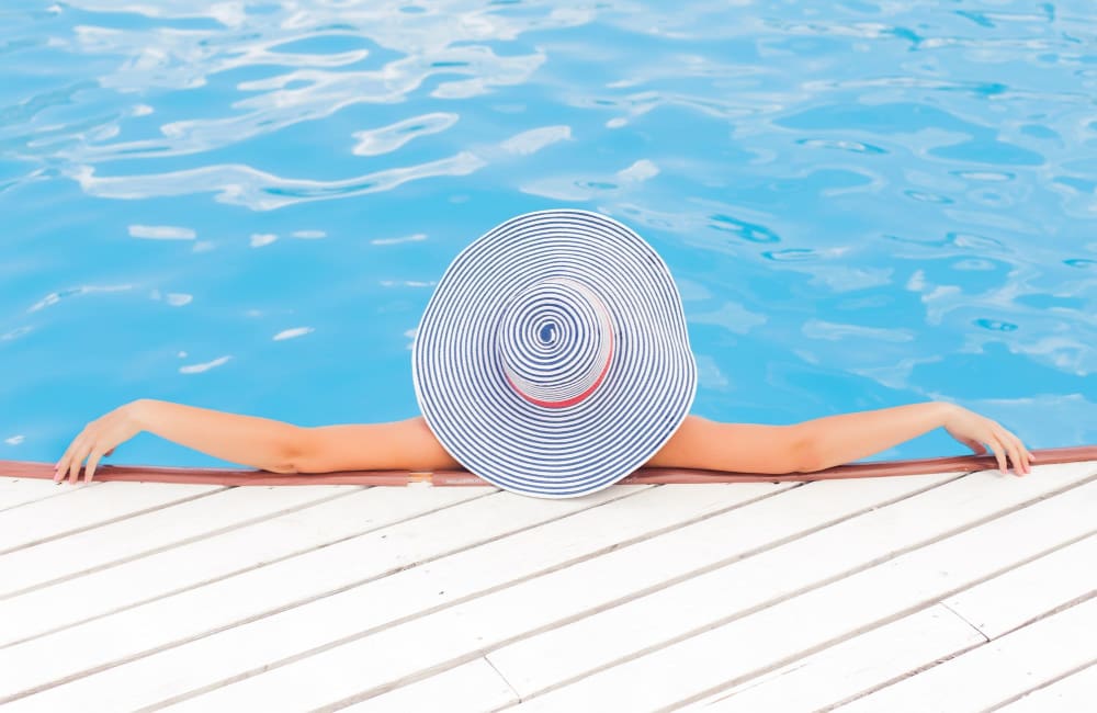 Resident relaxing in the pool at Bayside Villas Apartment Homes in South Pasadena, Florida