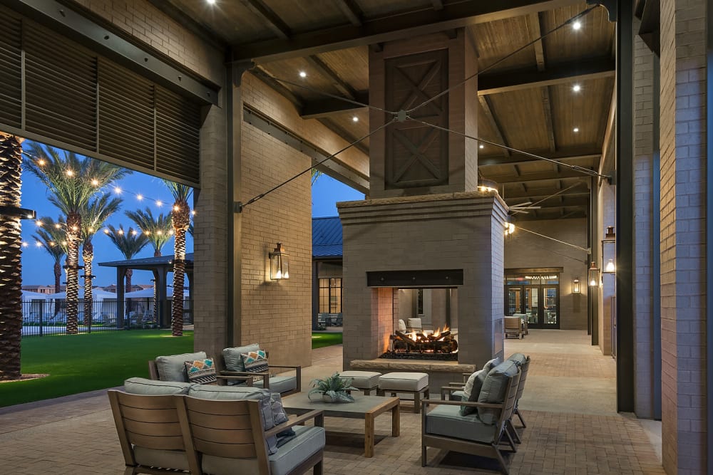 Comfortable seating next to the fireplace in the clubhouse with roll up doors at BB Living at Union Park in Phoenix, Arizona