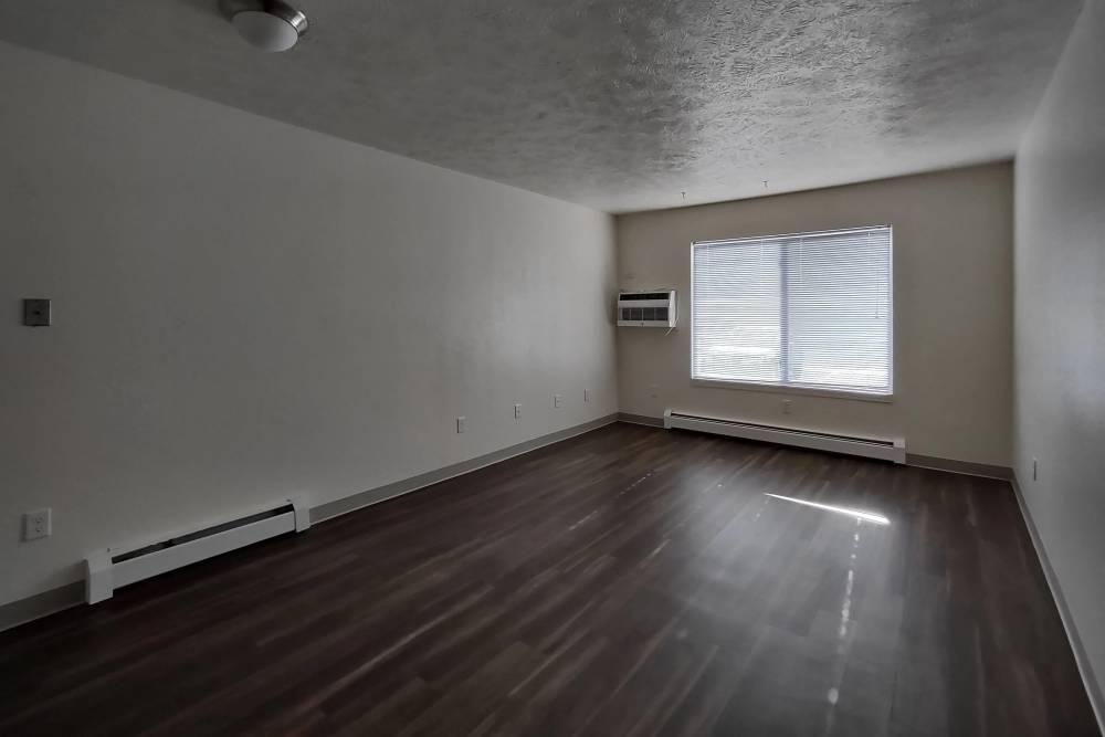 Spacious living room with windows at Willow Creek Apartments in Escanaba, Michigan