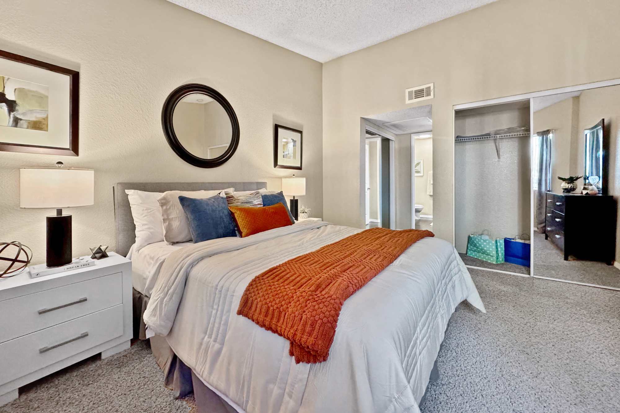 Decorated master bedroom with large windows at Tuscany Village Apartments in Ontario, California
