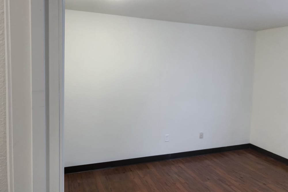 Spacious bedroom with wood-style flooring at Perry Acres Apartments in New Haven, Michigan, 