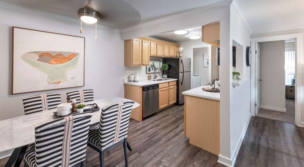Cozy kitchen with wood-style flooring and dining area at The Preserve at Forbes Creek in Kirkland, Washington