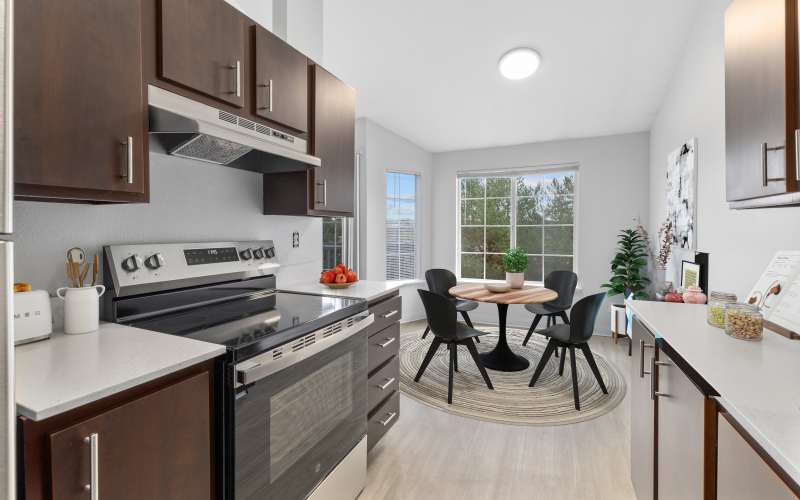 An updated kitchen with brown wood cabinets at Wellington Apartments in Silverdale, Washington