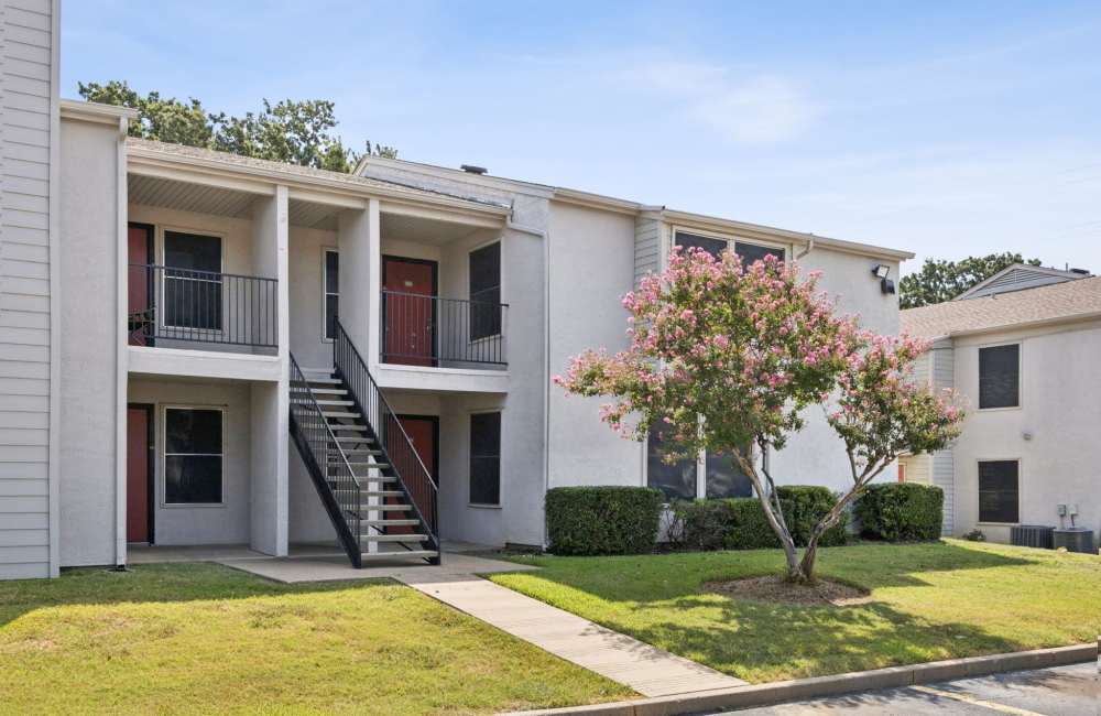 Beautiful exterior view of the apartment with black railing for upper level at Sleepy Hollow in Arlington, Texas 