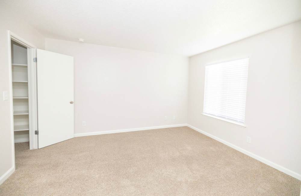Spacious bedroom with large windows at Riverview Gardens Apartments in Fresno, California