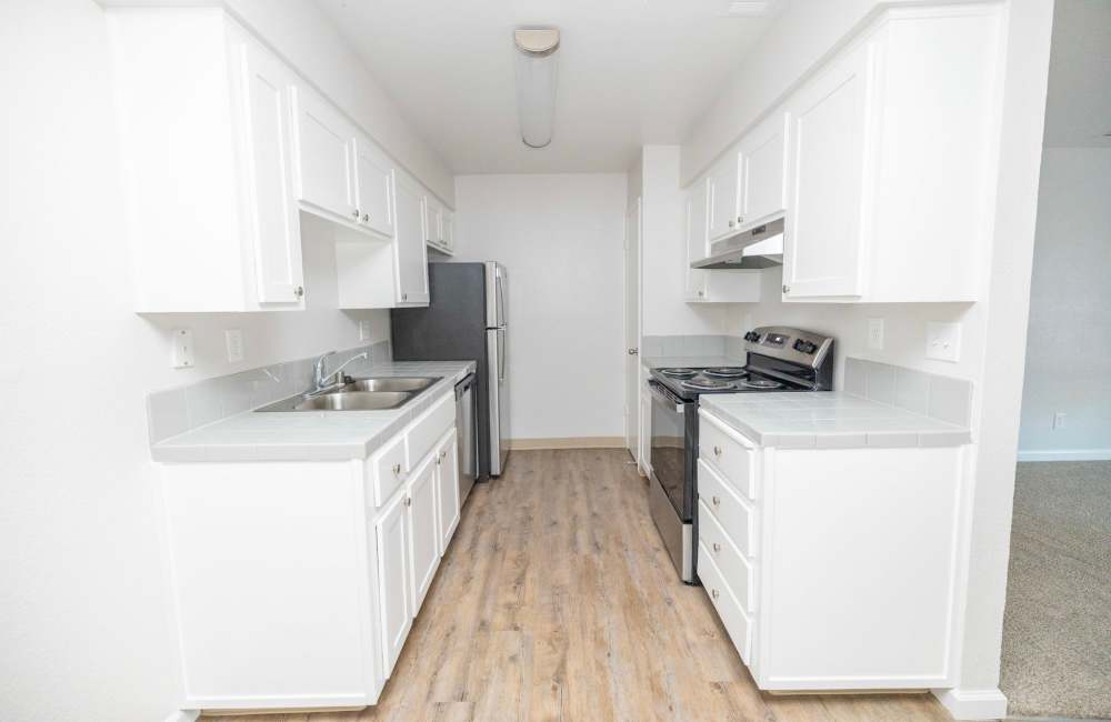 Kitchen with white wooden cabinets at Riverview Gardens Apartments in Fresno, California