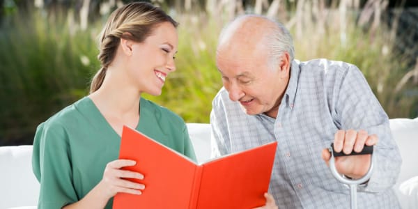 Resident reading a book with his caregiver at Ingleside Communities in Mount Horeb, Wisconsin