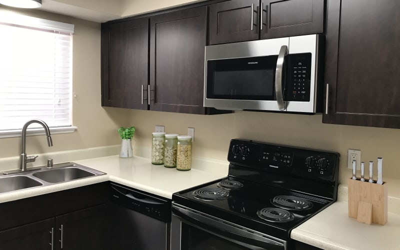 Renovated kitchen with espresso cabinets and stainless steel appliances at Bennington Apartments in Fairfield, California