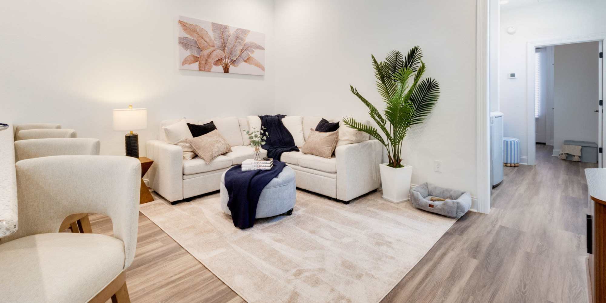 Bright living room with wood-style flooring, cozy sofa, and decorative plants, ideal for relaxing and entertaining at Lakewood Villas in Bossier City, Louisiana