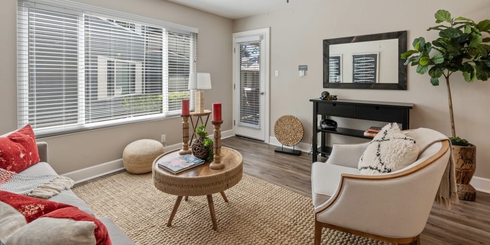 Beautiful model living room with wood-style flooring at Pinebrook Apartments in Fremont, California