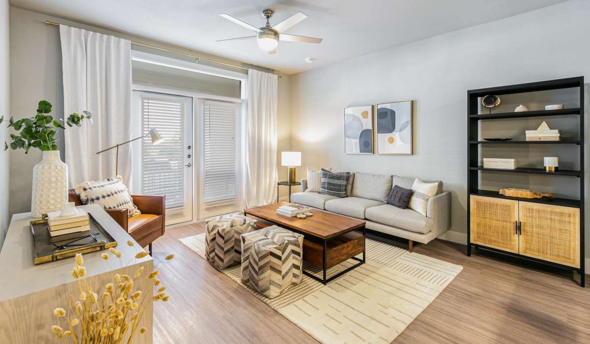 A cozy living room with a comfortable couch, a coffee table and access to balcony at The View at Belterra in Austin, Texas
