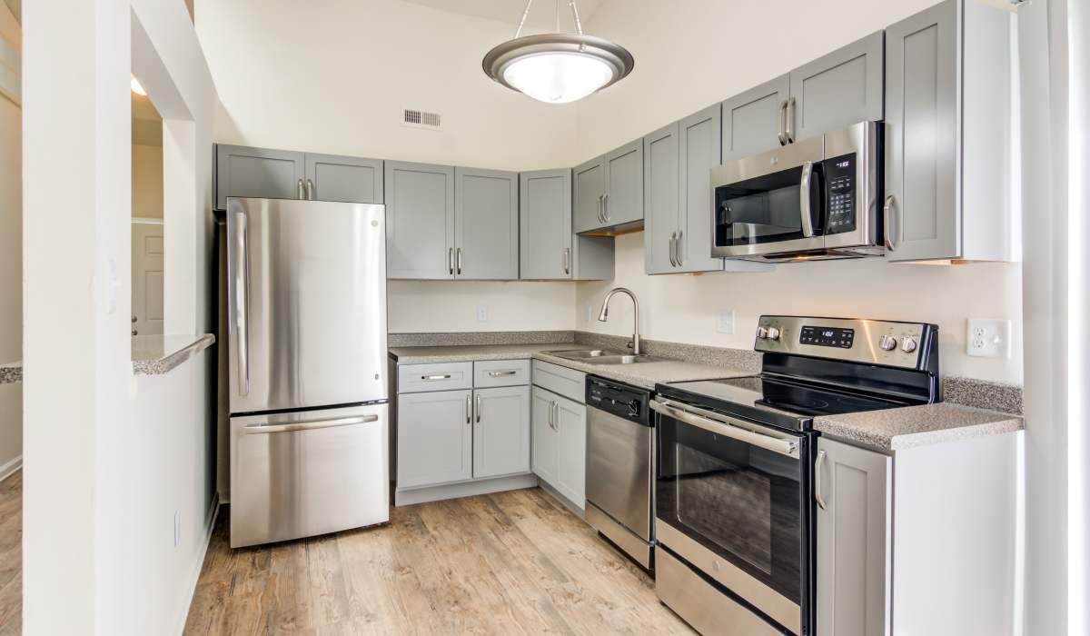 A bright apartment kitchen with wood-style flooring at Doria Apartments and Townhomes in Virginia Beach, Virginia
