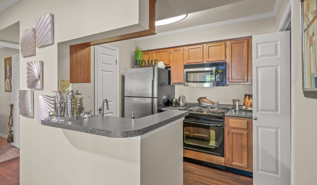 Kitchen with wooden cabinets, granite countertops and stainless-steel appliances at The Willows in Shreveport, Louisiana