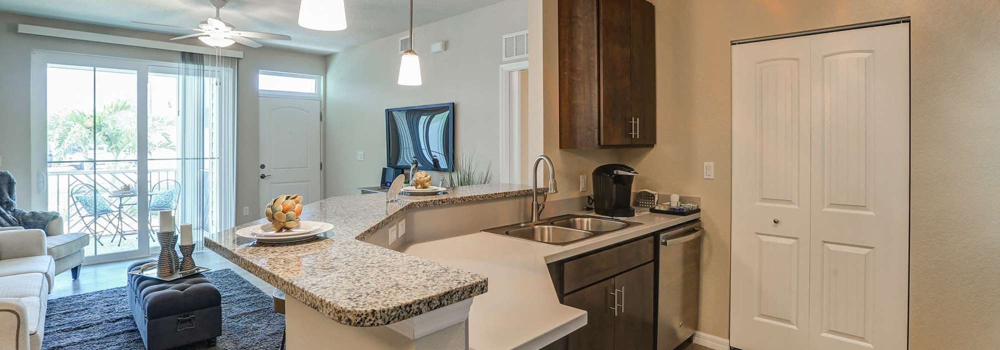Charming kitchen and living space with modern finishes and natural light at Lemon Bay Apartments in Englewood, Florida.