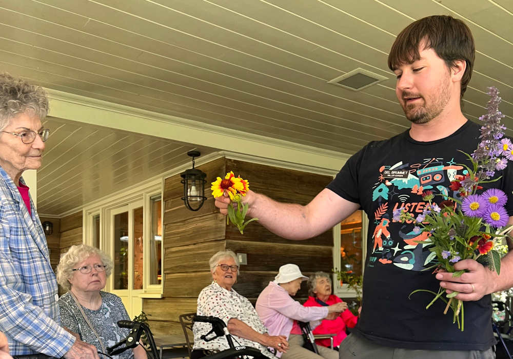 Residents getting handed flowers at Merrill Gardens at The University in Seattle, Washington